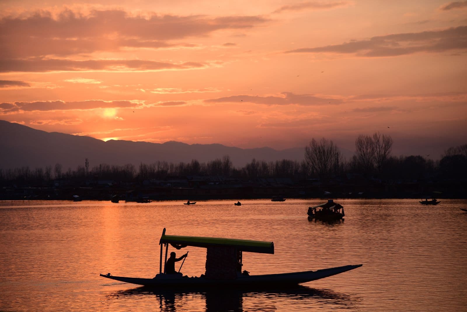 A shikara crossing Dal Lake at sunset in Kashmir